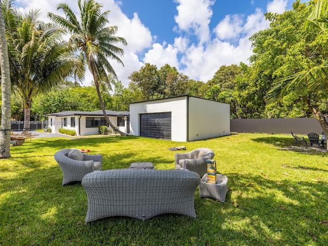 view of yard featuring a garage and an outdoor hangout area