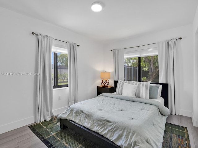 bedroom featuring multiple windows and hardwood / wood-style floors