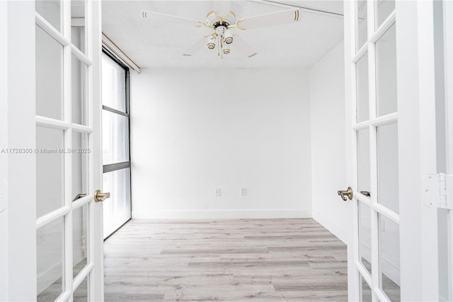 spacious closet with light wood-type flooring and french doors