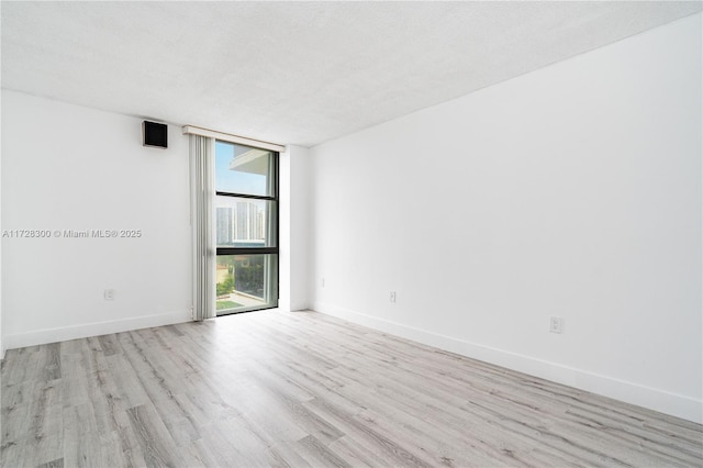 empty room featuring a textured ceiling and light wood-type flooring