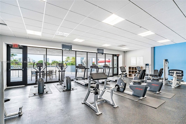 workout area with a healthy amount of sunlight, a drop ceiling, and french doors