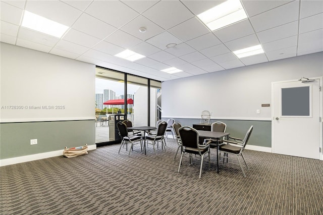 carpeted dining room featuring a drop ceiling and floor to ceiling windows