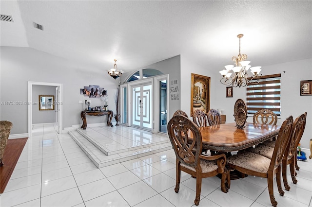 dining area with an inviting chandelier, light tile patterned floors, visible vents, and vaulted ceiling