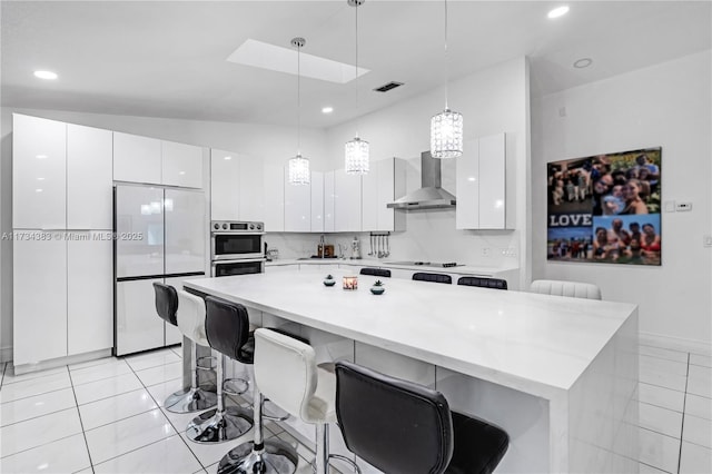 kitchen featuring wall chimney range hood, white cabinetry, white appliances, and light countertops