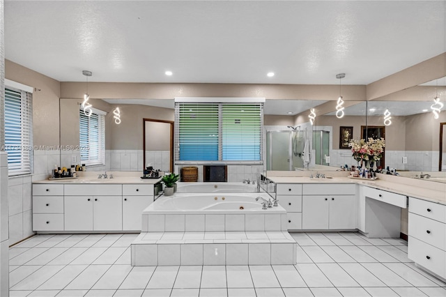 bathroom with a shower stall, two vanities, a sink, and tile patterned floors