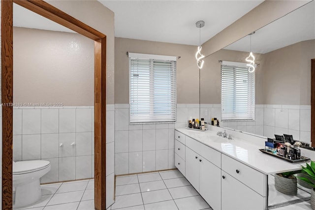 bathroom featuring tile patterned flooring, vanity, and tile walls