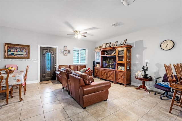 living room featuring a ceiling fan, visible vents, baseboards, and light tile patterned floors