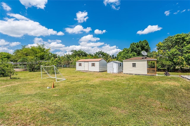 view of yard featuring a storage unit, an outdoor structure, and fence