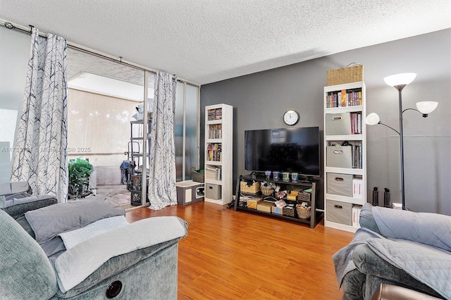 living room with wood-type flooring and a textured ceiling