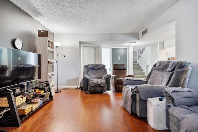 living room with hardwood / wood-style flooring and a textured ceiling