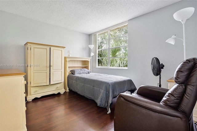 bedroom featuring dark hardwood / wood-style floors and a textured ceiling