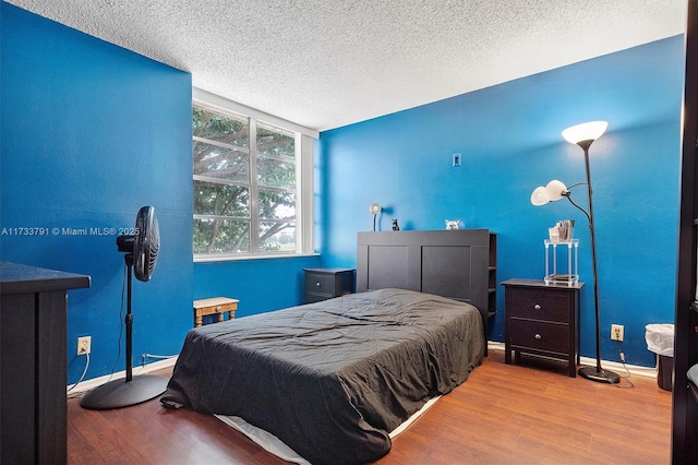 bedroom with a textured ceiling and light wood-type flooring