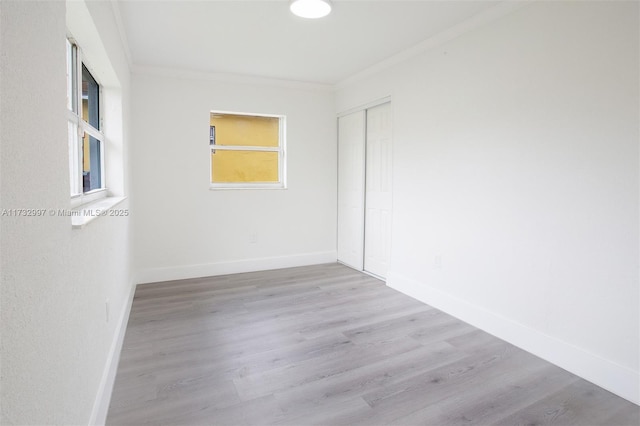 empty room featuring crown molding and light hardwood / wood-style flooring