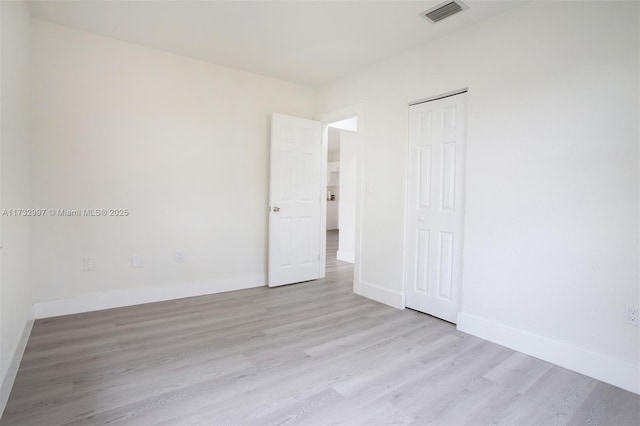 unfurnished bedroom featuring light hardwood / wood-style floors and a closet