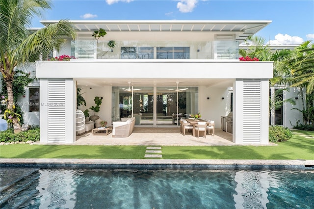 back of property featuring a yard, a patio area, and a balcony