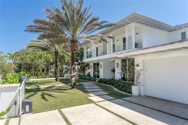 view of side of property featuring a yard, a garage, and stucco siding