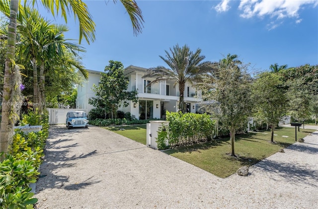 view of front of home with a front yard, driveway, a fenced front yard, and stucco siding