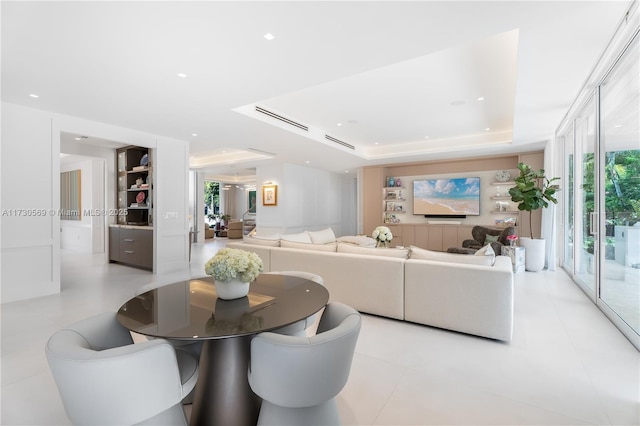 living area with a raised ceiling and visible vents