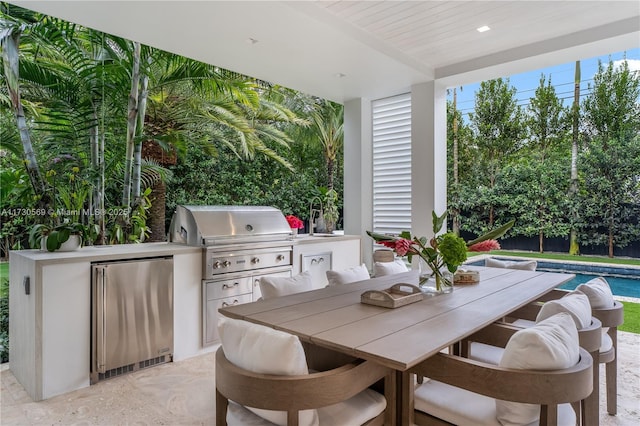 view of patio / terrace with outdoor dining space, an outdoor kitchen, a grill, and an outdoor pool