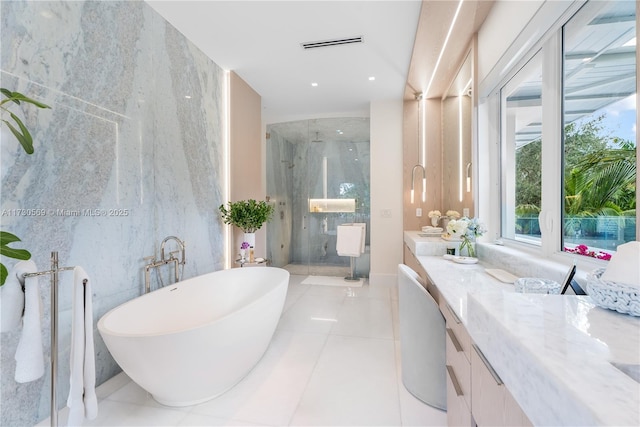 full bath featuring vanity, visible vents, a marble finish shower, a freestanding tub, and tile patterned floors