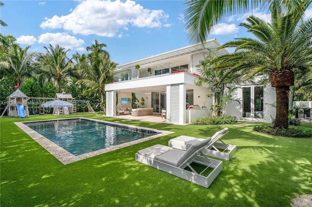 rear view of house featuring a patio, a balcony, playground community, a yard, and outdoor lounge area