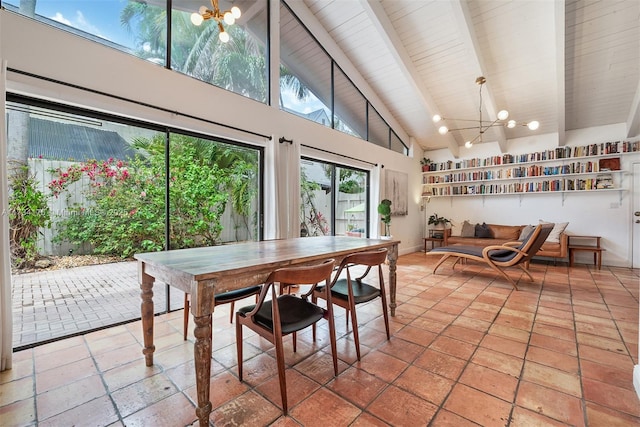 sunroom / solarium featuring lofted ceiling with beams and a notable chandelier