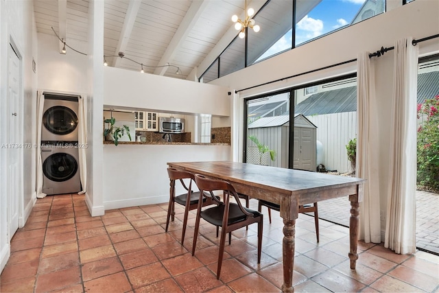 dining space with stacked washer and clothes dryer, a chandelier, high vaulted ceiling, wooden ceiling, and beam ceiling