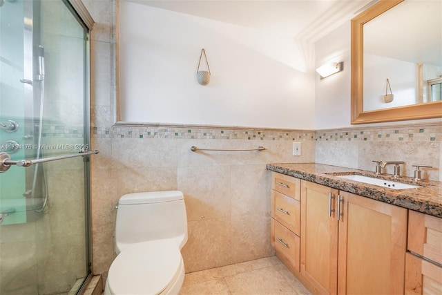 bathroom with tile patterned floors, toilet, tile walls, and vanity