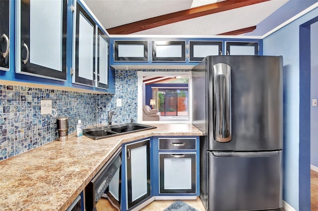 kitchen featuring stainless steel refrigerator, sink, beam ceiling, and blue cabinetry