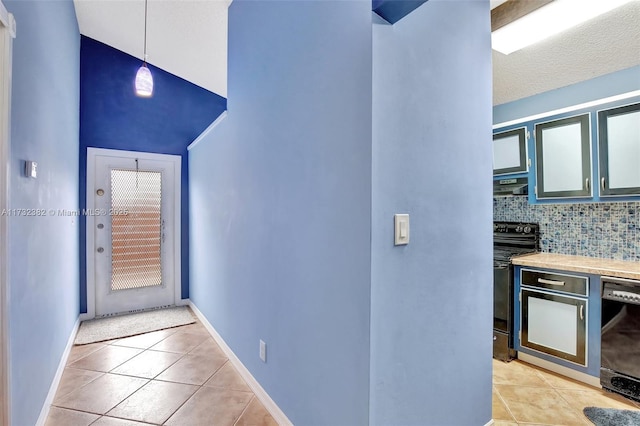 hall featuring light tile patterned floors and a textured ceiling