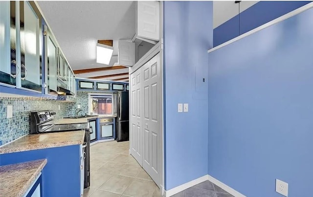 kitchen featuring black refrigerator, tasteful backsplash, light tile patterned floors, electric range, and beam ceiling