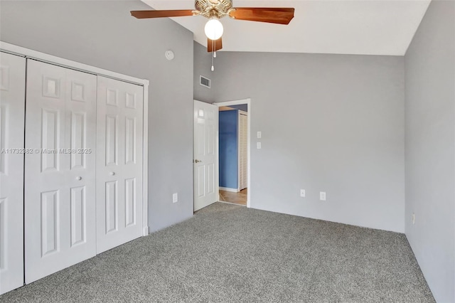 unfurnished bedroom featuring high vaulted ceiling, carpet flooring, ceiling fan, and a closet