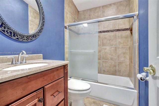 full bathroom featuring vanity, tile patterned flooring, bath / shower combo with glass door, and toilet