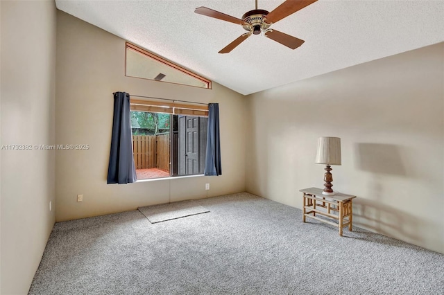 unfurnished room with lofted ceiling, carpet floors, and a textured ceiling