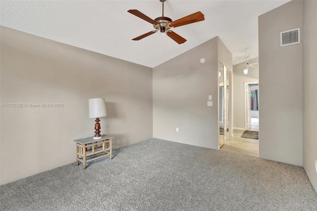 carpeted spare room with lofted ceiling and ceiling fan