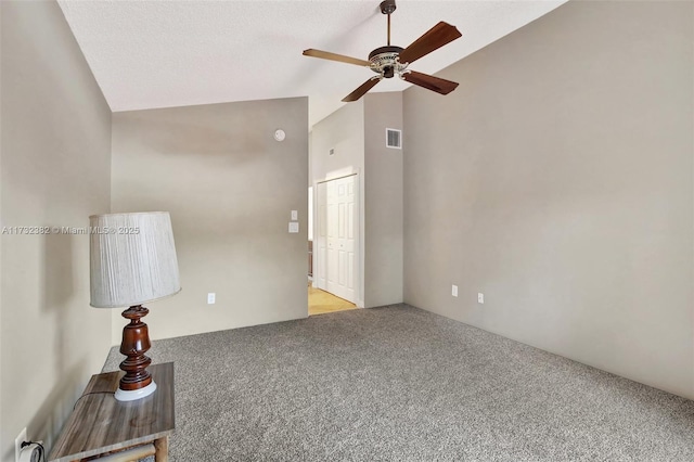 carpeted empty room with ceiling fan and lofted ceiling