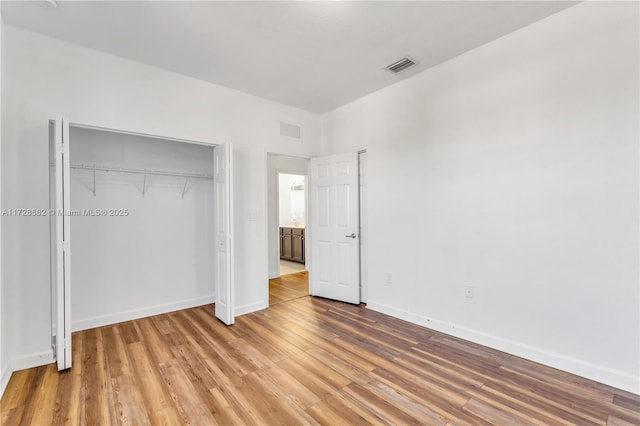 unfurnished bedroom with wood-type flooring and a closet