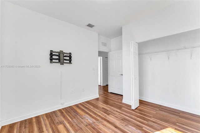 unfurnished bedroom with wood-type flooring and a closet