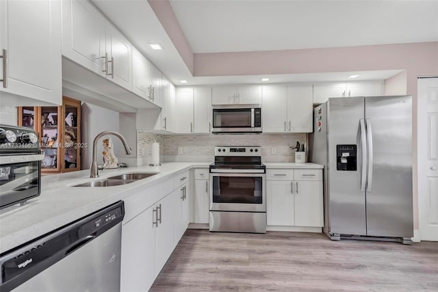 kitchen featuring stainless steel appliances, tasteful backsplash, sink, and white cabinets