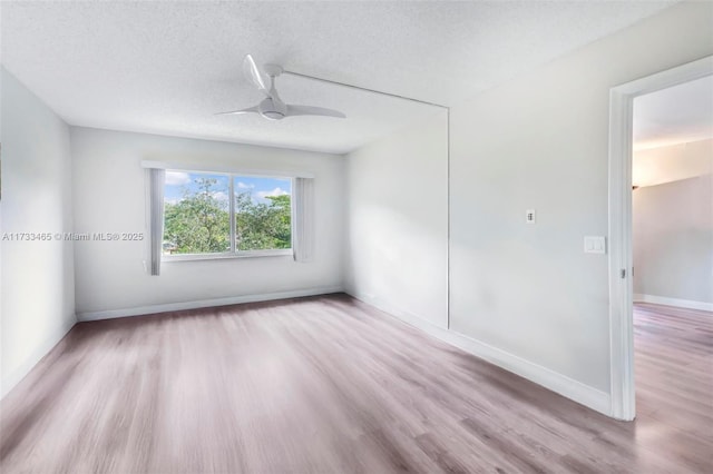 1401 SW 128th Ter Unit 307H, Pembroke Pines, FL 33027 - spare room with baseboards, a ceiling fan, a textured ceiling, and wood finished floors