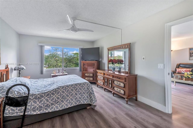 bedroom with hardwood / wood-style floors, a textured ceiling, and ceiling fan