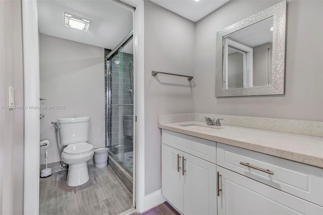 bathroom featuring vanity, toilet, an enclosed shower, and hardwood / wood-style floors