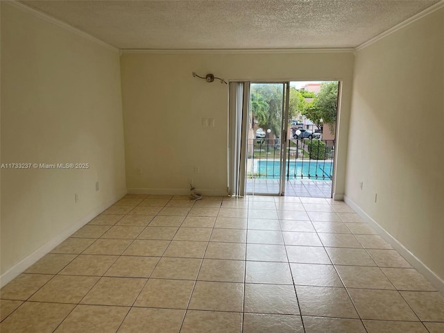 tiled empty room featuring crown molding and a textured ceiling