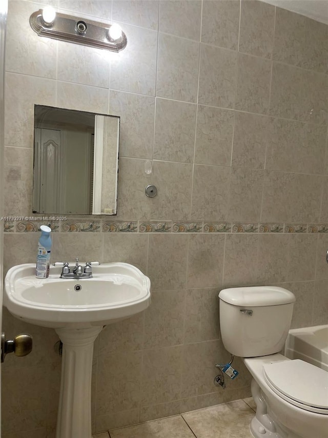 bathroom featuring tile patterned floors, toilet, tile walls, and backsplash