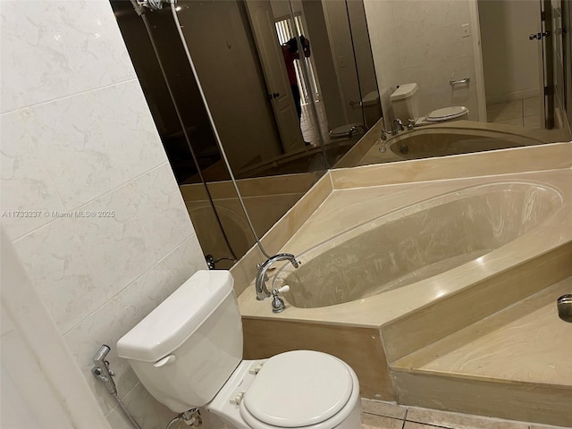 bathroom featuring toilet, tile patterned flooring, and tile walls