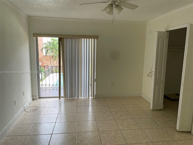 tiled spare room featuring ceiling fan, crown molding, and a textured ceiling