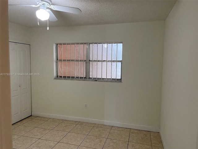 unfurnished room featuring ceiling fan, a textured ceiling, and light tile patterned flooring