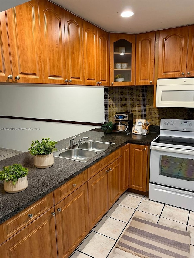 kitchen with tasteful backsplash, sink, white appliances, and light tile patterned flooring