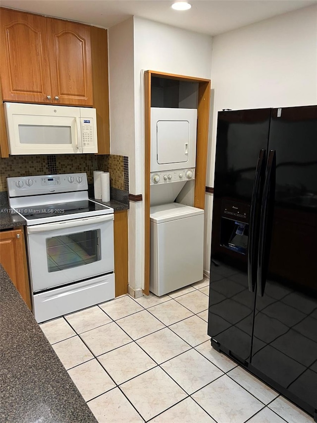 kitchen featuring tasteful backsplash, light tile patterned flooring, stacked washer and clothes dryer, and white appliances