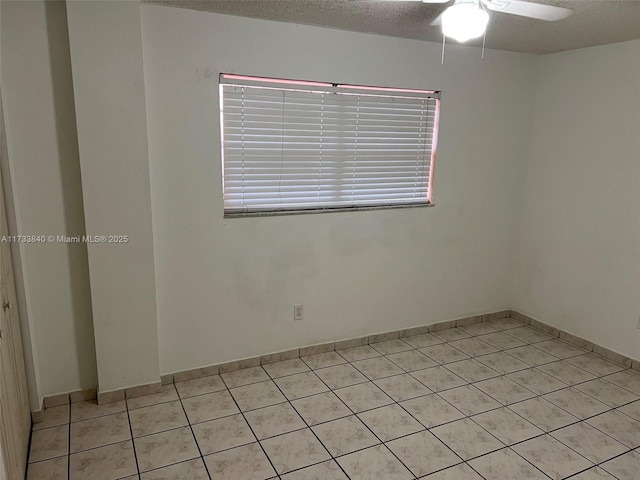 spare room with ceiling fan, a textured ceiling, and light tile patterned floors